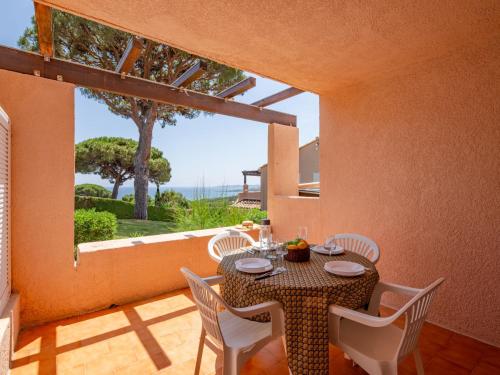 une salle à manger avec une table et des chaises et une grande fenêtre dans l'établissement Apartment Les Coteaux de la Nartelle-18 by Interhome, à Sainte-Maxime