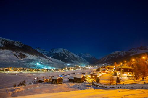 a town covered in snow at night with mountains at Cuore Alpino in Livigno