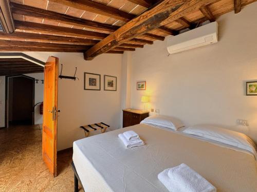 a bedroom with a white bed and a wooden ceiling at Le terrazze di Camollia in Siena