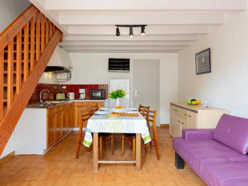 une cuisine avec une table et un canapé pourpre dans l'établissement Holiday Home Sicard-10 by Interhome, à Mimizan-Plage