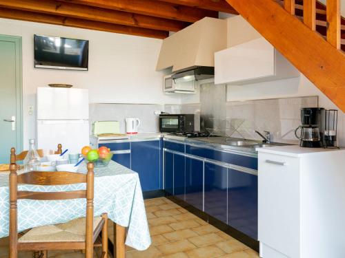 une cuisine avec des armoires bleues et une table dans l'établissement Holiday Home Sicard-2 by Interhome, à Mimizan-Plage