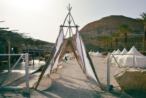 a tent on a beach with a mountain in the background at חאן מחצבת הגבס - Glamping Gypsum Quarry 