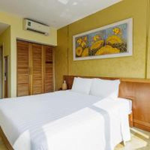 a bedroom with a large white bed with a picture on the wall at Dancenter Near Hoan Kiem Lake, Vincom Center Ba Trieu Formerly Le Grand The Sun in Hanoi