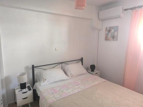 a bedroom with a bed and a white wall at Johanna's apartment in Preveza