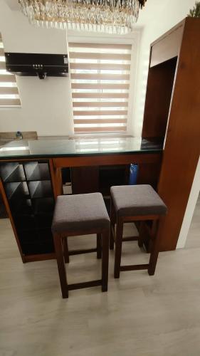 a kitchen with a counter with two stools and a desk at 3-Bedroom House in NorthPoint in Talisay