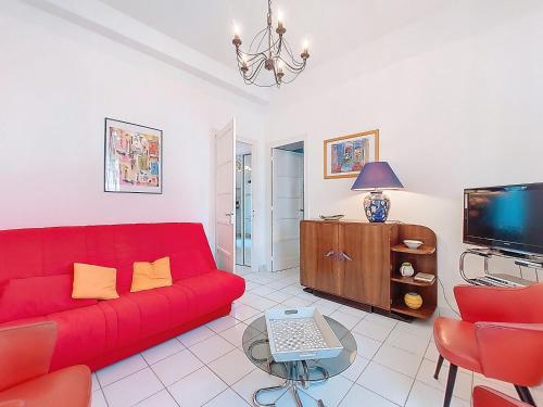 un salon avec un canapé rouge et une télévision dans l'établissement Apartment de la Plage et d'Angleterre by Interhome, à Royan