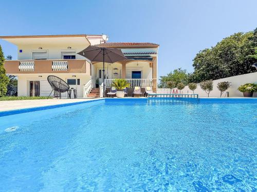 a large swimming pool in front of a house at Holiday Home Tina & Tino by Interhome in Briševo