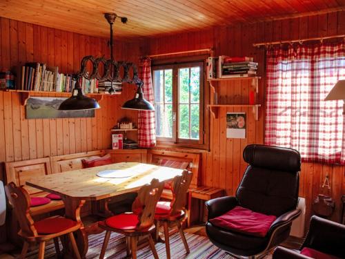 a dining room with a wooden table and chairs at Chalet Henri by Interhome in Moleson