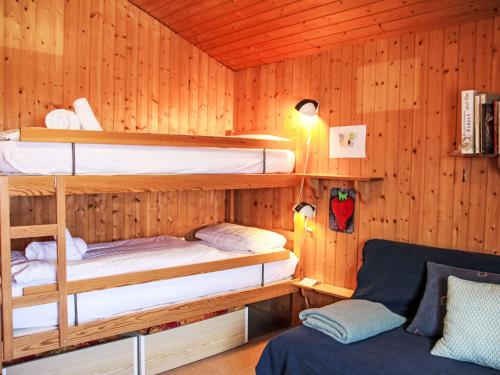 a room with two bunk beds and a couch at Chalet Henri by Interhome in Moleson