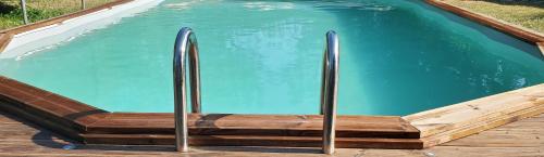 une piscine avec deux poteaux métalliques à l'intérieur dans l'établissement Gîte AnjouLoire, à Saint-Mathurin