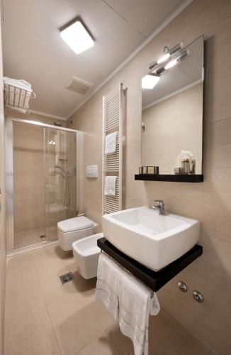 a bathroom with a sink and a toilet and a mirror at Ca' Pozzo Inn in Venice