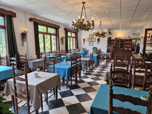 a dining room with tables and chairs and a chandelier at Hôtel Val Du Tech in Prats-de-Mollo-la-Preste
