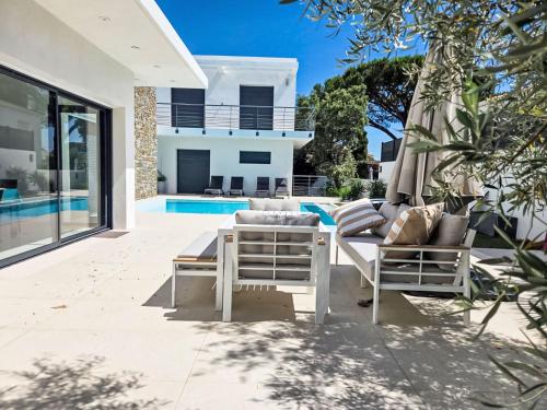 un patio avec un parasol et des chaises et une piscine dans l'établissement Holiday Home L'Oustaloun by Interhome, à Saint-Aygulf