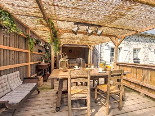 une terrasse en bois avec une table et des chaises en bois dans l'établissement Holiday Home Le logis de Papeu by Interhome, à Fréhel
