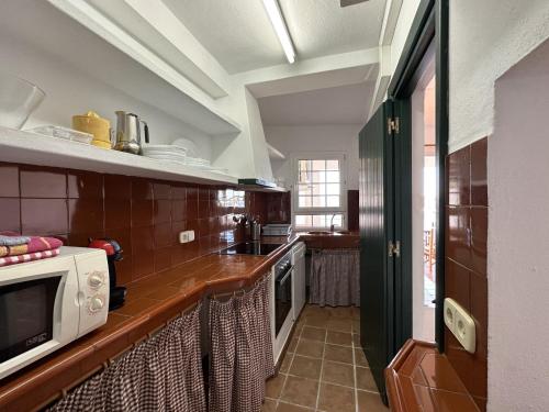 a kitchen with a counter top with a microwave at ESCOPINYA by SOM Menorca in Fornells