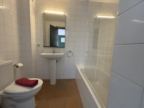 a bathroom with a toilet and a sink and a tub at ESCOPINYA by SOM Menorca in Fornells