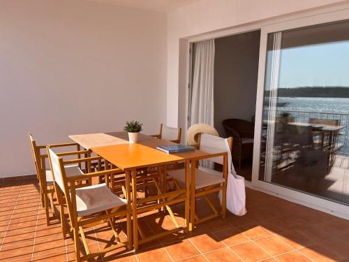 a dining room table and chairs with a view of the ocean at ESCOPINYA by SOM Menorca in Fornells