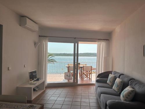 a living room with a couch and a view of the ocean at ESCOPINYA by SOM Menorca in Fornells