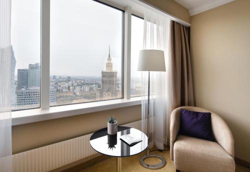 a room with a chair and a table and a window at Warsaw Presidential Hotel in Warsaw