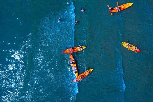a group of people on surfboards in the water at Villaggio San Francesco - Adria Holiday Mobile Homes in Duna Verde