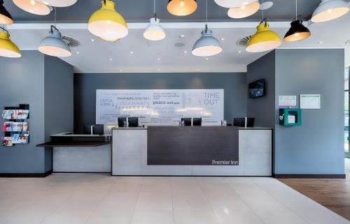 a restaurant with a counter with lights on the wall at Premier Inn Lübeck City Centre in Lübeck