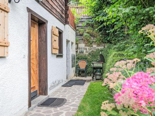a patio with a table and a chair in a yard at Chalet Le Coeur by Interhome in Ovronnaz