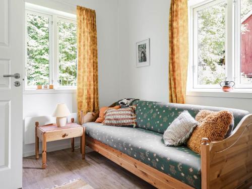 a living room with a couch and two windows at Holiday Home Sjödrömmen by Interhome in Näsviken