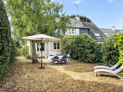 a patio with chairs and an umbrella in front of a house at Holiday Home Arvor I-2 by Interhome in Carnac