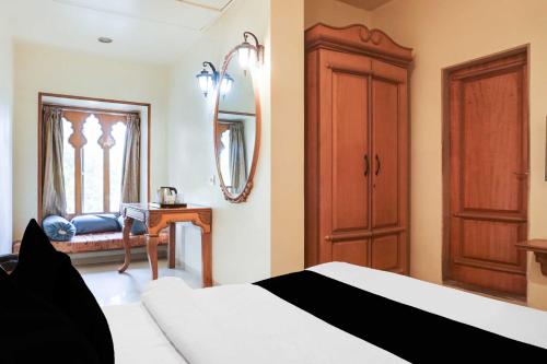 a bedroom with a bed and a mirror and a table at Collection O Baner Road Pune formerly Hotel Rajwada in Dāpuri