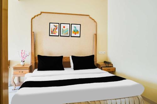 a bedroom with a large white bed with three pictures on the wall at Collection O Baner Road Pune formerly Hotel Rajwada in Dāpuri