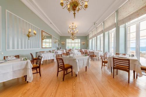 a restaurant with white tables and chairs and a chandelier at Pousada de Viana do Castelo in Viana do Castelo