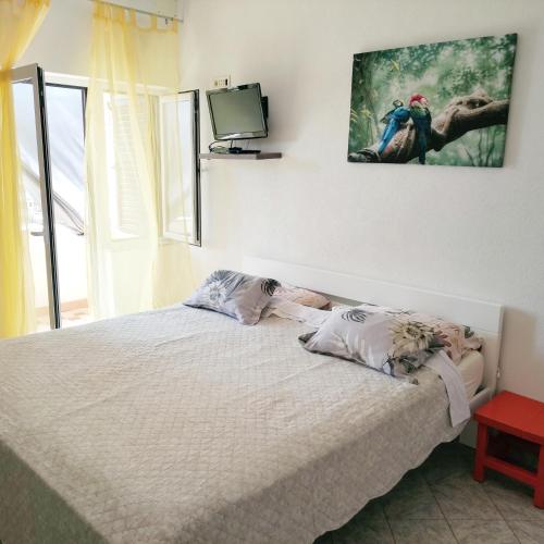 a bedroom with a bed with a tv on the wall at Lovrić Studio mit Balkon in Jurandvor