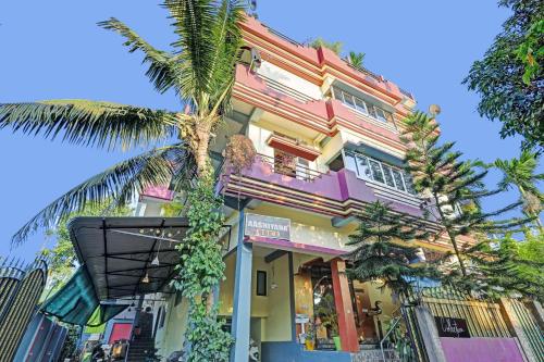 a building with a palm tree in front of it at Hotel O Aashiyana Home in Dibrugarh