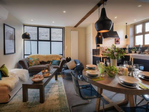 un salon avec une table et un canapé dans l'établissement Maison Guigone - OVO Network, à Beaune