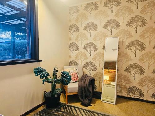 a room with a chair and a wall with a tree wallpaper at 3 Bdrm home,pool, BBQ , fireplace Great for a weekend of fun or family retreat in Croydon
