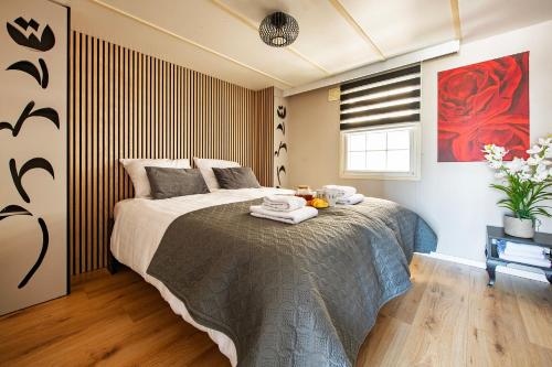 a bedroom with a bed with towels on it at 13, Artist-Designed with AC, Parking & Fully Fenced! in Oisterwijk