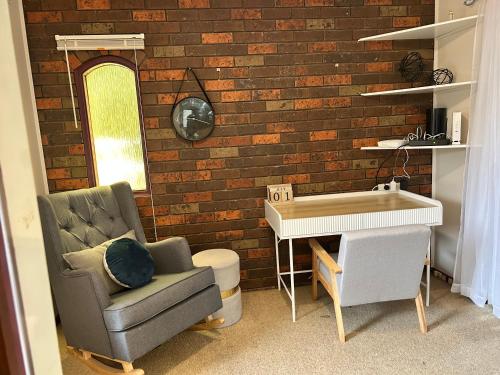 a living room with a chair and a desk at 3 Bdrm home,pool, BBQ , fireplace Great for a weekend of fun or family retreat in Croydon