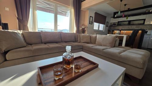 a living room with a couch and two glasses on a table at Sarajevo Sky View in Sarajevo