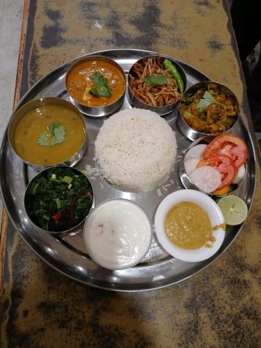 a plate of food with rice and different types of food at Hotel Dev Inn in Dhangadhi