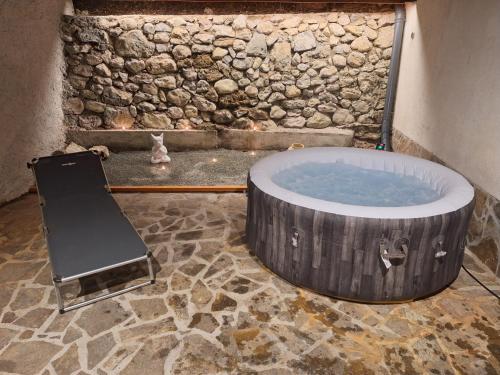 a hot tub in a room with a stone wall at Vila Anton in Dobrna