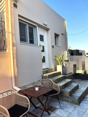 a patio with two chairs and a table and stairs at Petra Phos in Ermoupoli