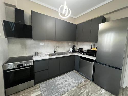 a kitchen with black cabinets and a stainless steel refrigerator at Modern Makri in Mákri