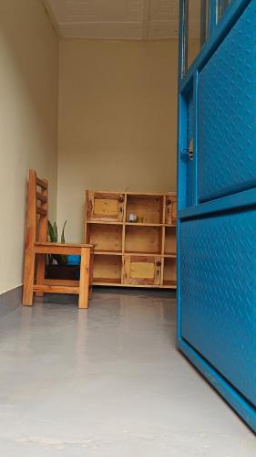 a room with a blue door and a bench in a room at Eco Cribs in Masaka
