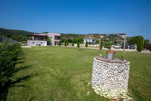 a garden with a rock fountain in a yard at V la vie in Ioannina