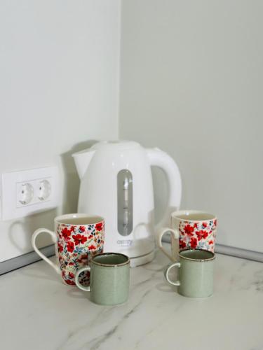 three coffee cups sitting on a counter next to a toaster at Stara Žaga in Bled