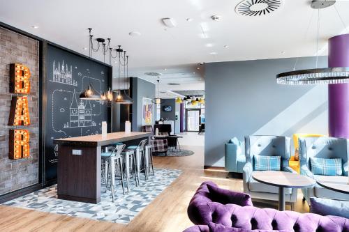 a lobby with a bar and tables and chairs at Premier Inn Lübeck City Centre in Lübeck