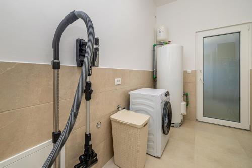a bathroom with a washing machine and a washer at Villa FUSKA with private pool in Pinezici