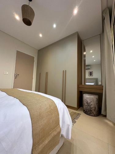 a bedroom with a white bed and a desk at First Row to Pyramids 2BDR Apt in Kafrat Naşşār
