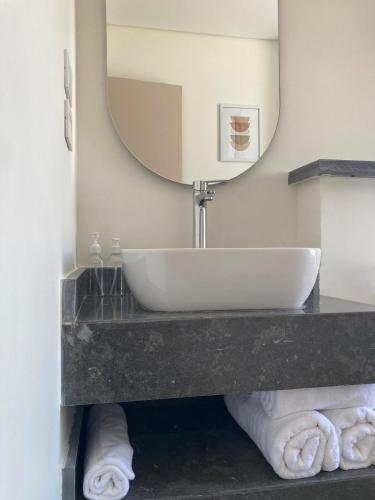 a bathroom with a sink and a mirror at First Row to Pyramids 2BDR Apt in Kafrat Naşşār