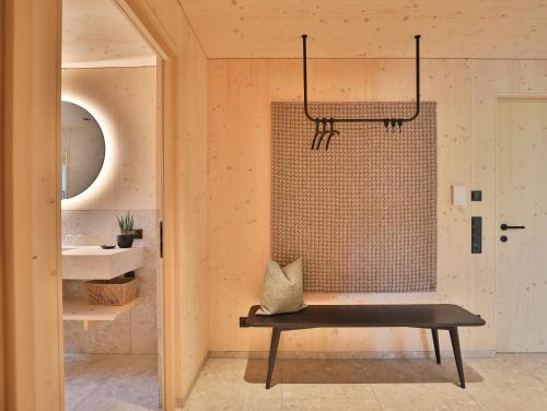a bathroom with a bench and a sink at Mair am Graben Farm Chalets in Terento